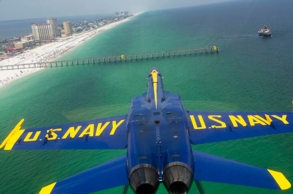 Blue Angels Boeing F/A-18 Super Hornet flies over Pensacola Beach and Pensacola Beach Pier during a flight demonstration.