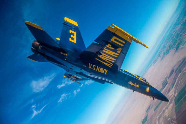 Blue Angel No. 3 Boeing F/A-18 Super Hornet performs a high-speed banking maneuver during a flight demonstration.