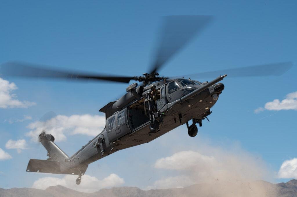 HH-60W Jolly Green II banks in flight with door gunner visible