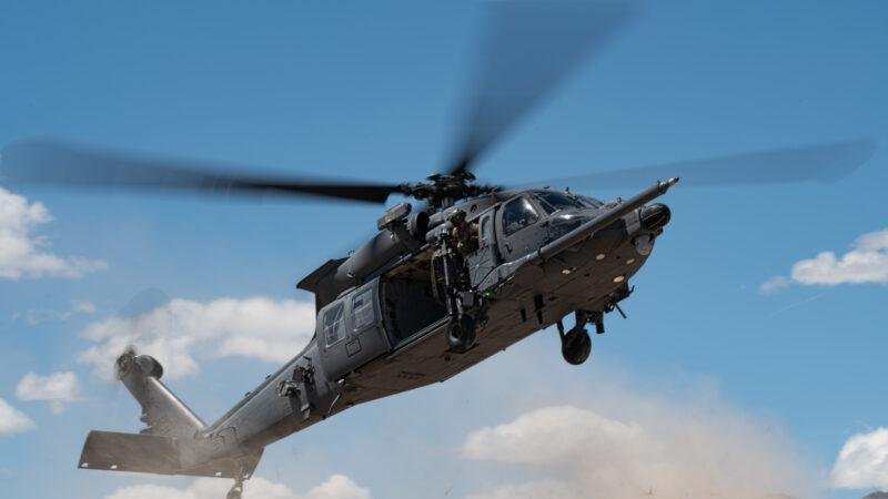 HH-60W Jolly Green II banks in flight with door gunner visible