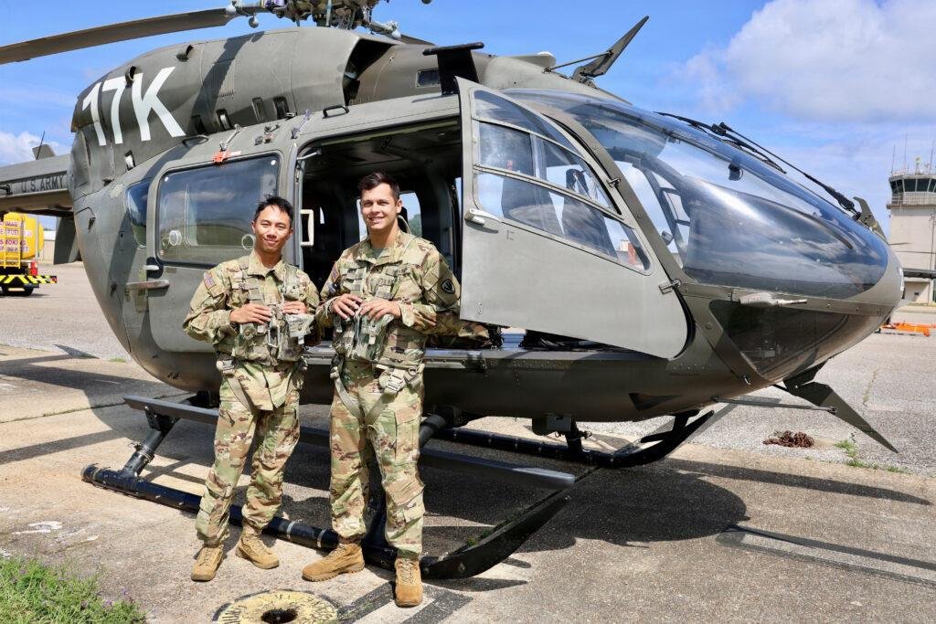 Army flight school students with LUH-72 Lakota helicopter after first solo cross-country flight at Fort Rucker