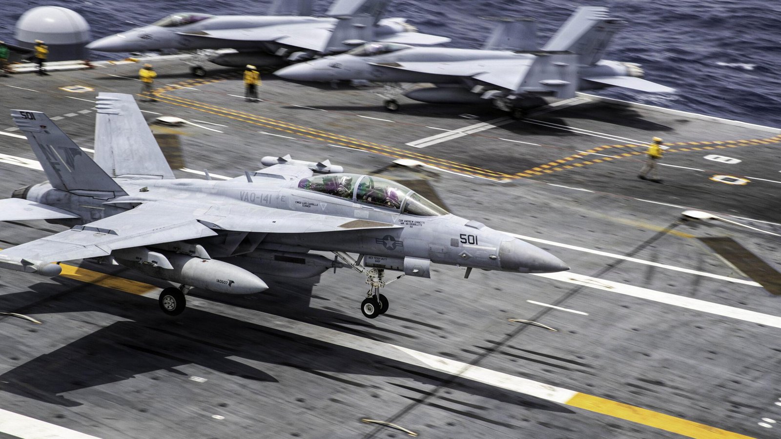 VAQ-141 EA-18G Growler on an aircraft carrier flight deck with an ALQ-99 jamming pod