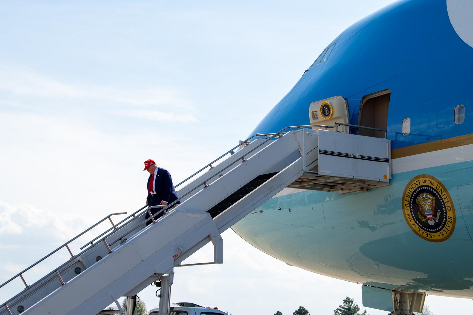 President Trump walks down the stairs of the VC-25A Air Force One on the tarmac