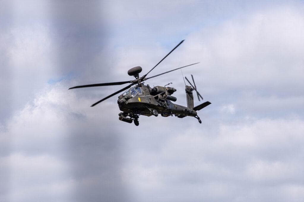 AH-64 Apache attack helicopter flying against cloudy sky
