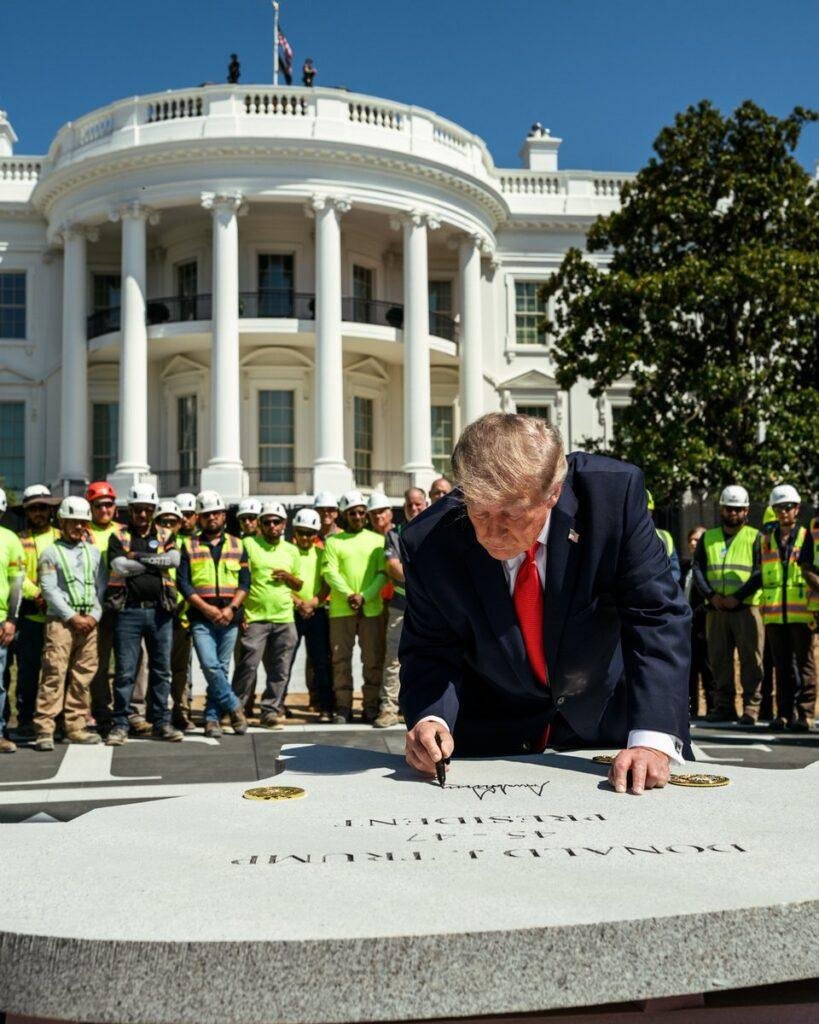 President Donald Trump signs a granite section of the new White House South Lawn helipad in August 2026