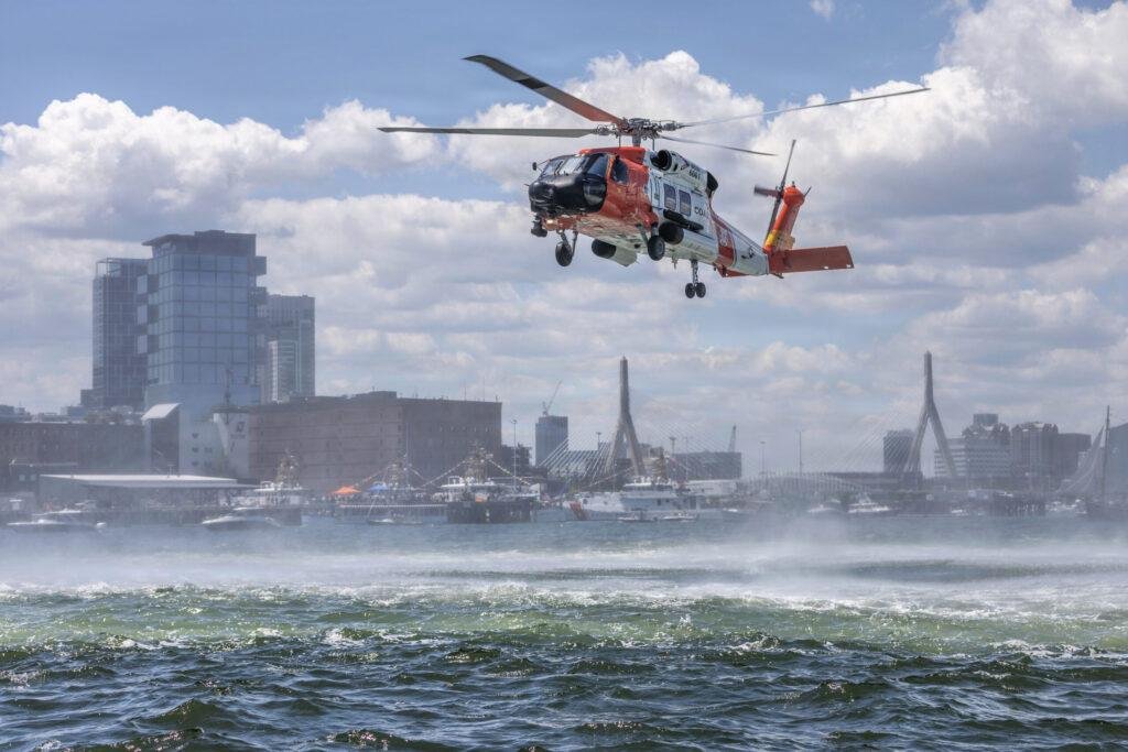 U.S. Coast Guard 236th Birthday feature image showing a Coast Guard helicopter conducting a maritime flight over Boston Harbor.