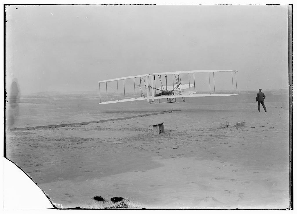Orville Wright pilots the Wright Flyer during the first powered flight at Kitty Hawk on December 17, 1903