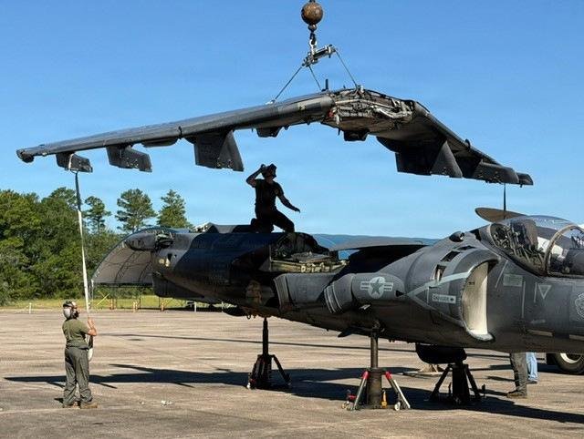 Technician guides a detached wing from the last USMC-built AV-8B Harrier II as it's lifted by crane at MCAS Cherry Point