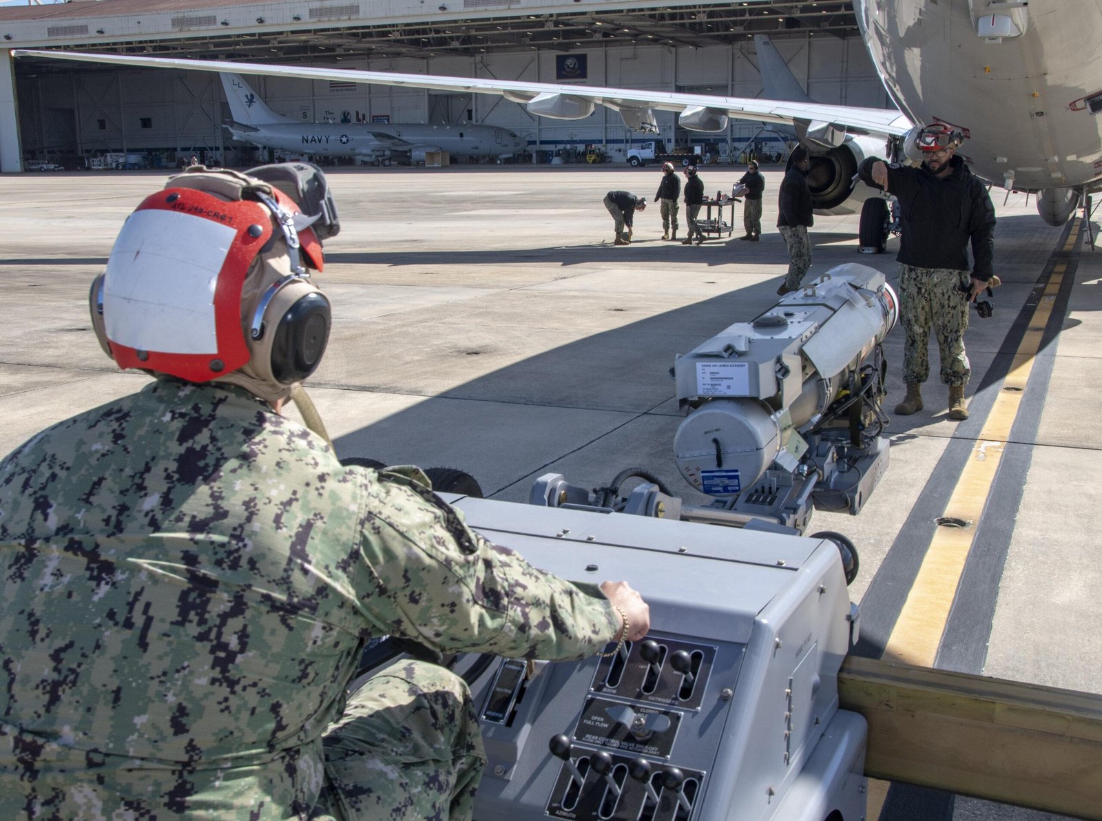 Sailors move a HAAWC glide kit toward a P-8A Poseidon, the system the Silent Anvil torpedo would improve on
