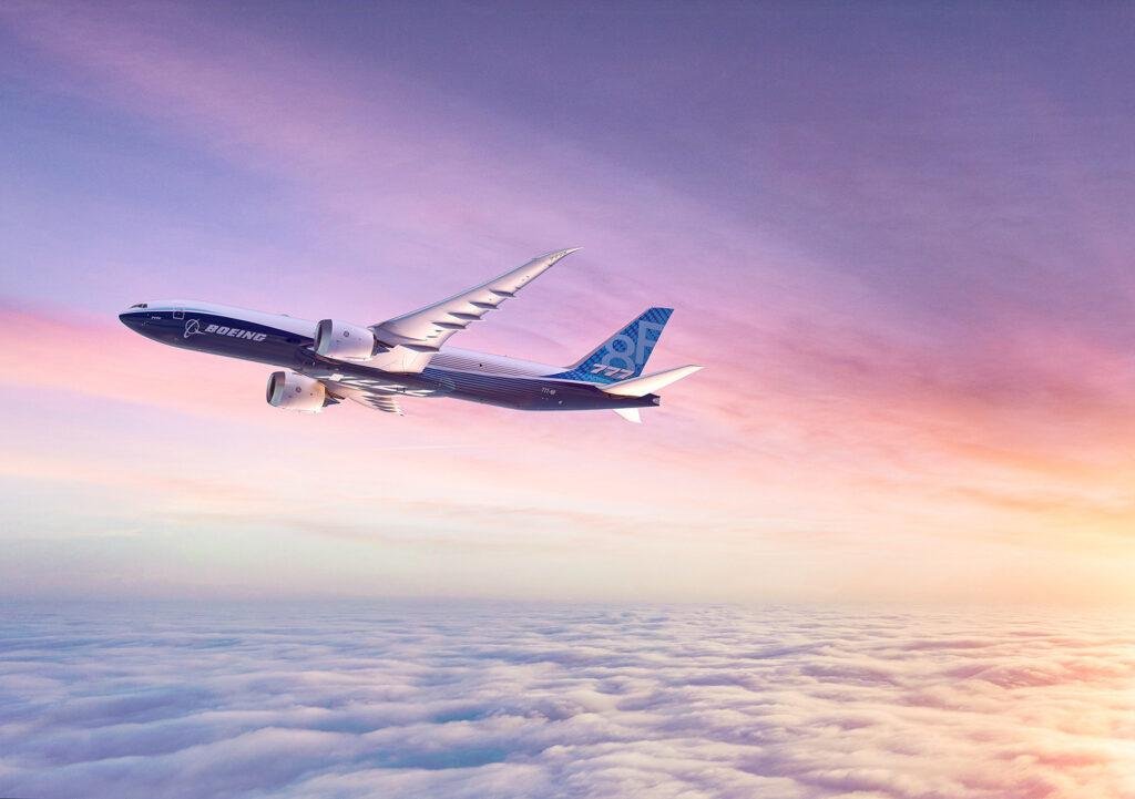 Boeing 777-8 Freighter flying above clouds at sunset