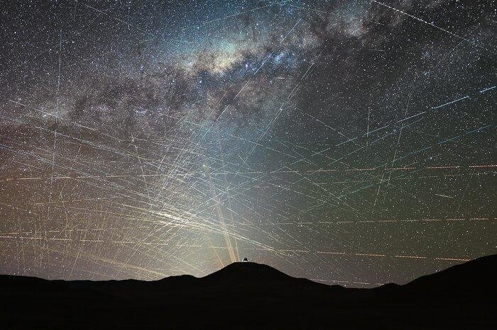 ESA satellite interference illustrated by numerous satellite trails crossing the night sky above astronomical observatories in Chile's Atacama Desert.