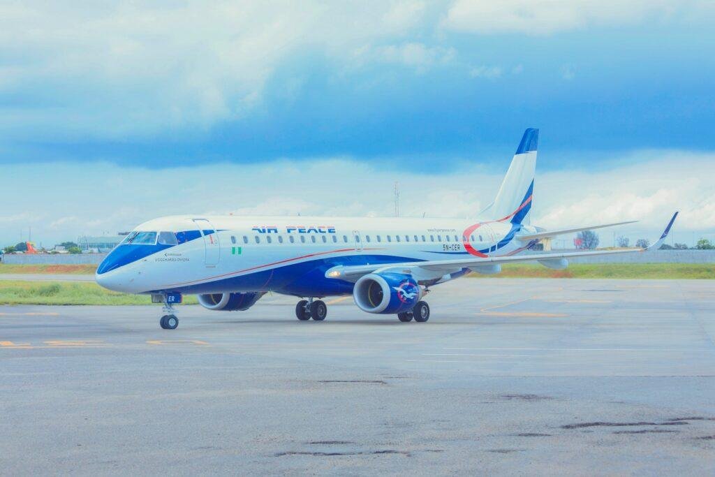 Air Peace Embraer E190 aircraft, registration 5N-CER, parked on an airport apron in Nigeria, displaying the airline's blue-and-white livery.