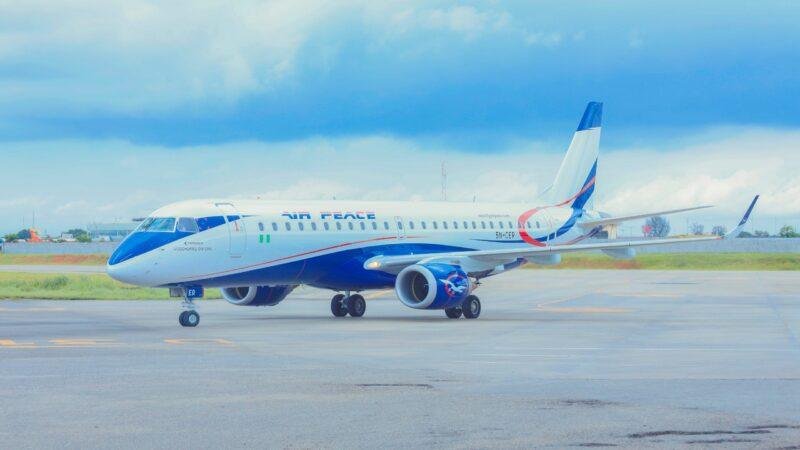 Air Peace Embraer E190 aircraft, registration 5N-CER, parked on an airport apron in Nigeria, displaying the airline's blue-and-white livery.