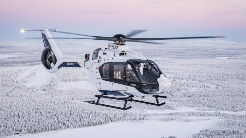 Airbus H140 tests during a cold-weather flight campaign, showing the helicopter flying over snow-covered forests.