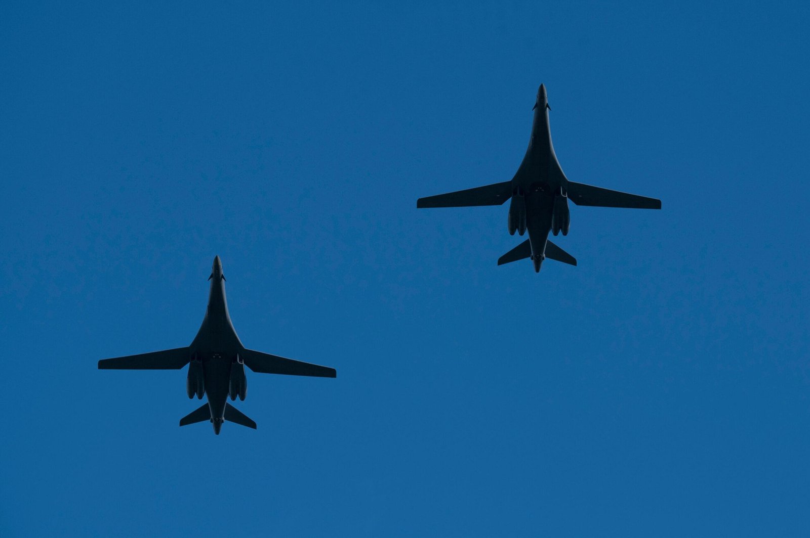 B-1B Lancer lifting off at dusk with afterburner flames glowing behind the engines
