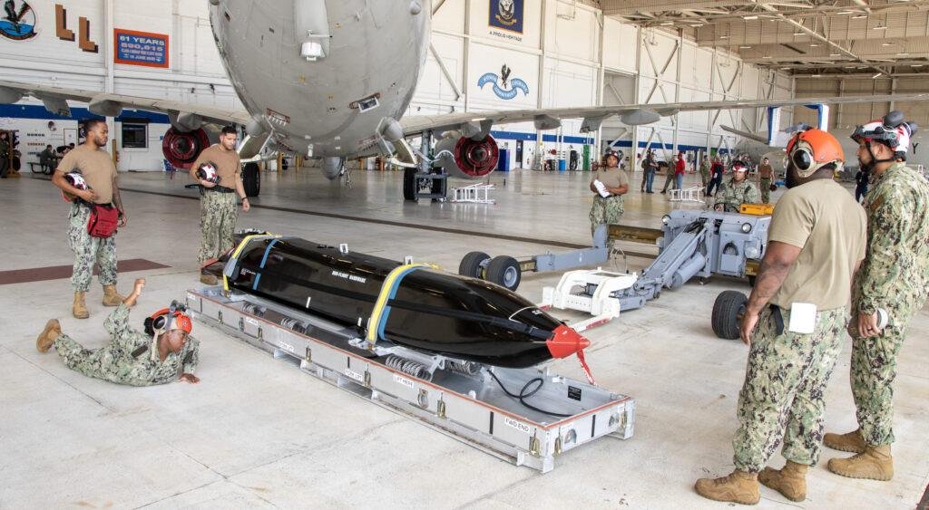 B-52 LRASM integration article illustrated by U.S. Navy personnel preparing an AGM-158C Long Range Anti-Ship Missile for loading onto a P-8A Poseidon.