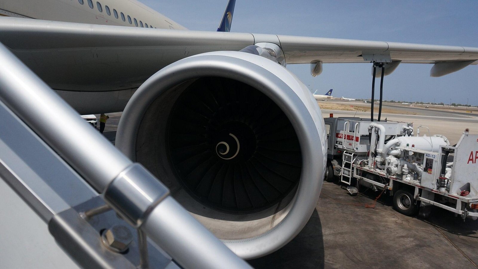 View into the intake of a Rolls-Royce Trent 700 engine on an Airbus A330, seen from the boarding stairs, showing its ring of fan blades and spiral-marked spinner