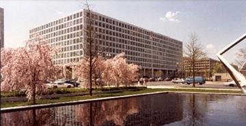 Federal Aviation Administration headquarters building in Washington, D.C., with trees and a reflecting pool in the foreground.