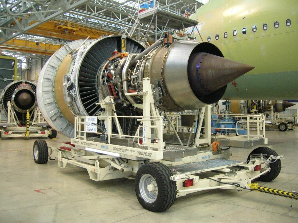 An uncowled Engine Alliance GP7200 turbofan on a wheeled transport cart inside an aircraft hangar, illustrating the FAA A380 engine seal directive.