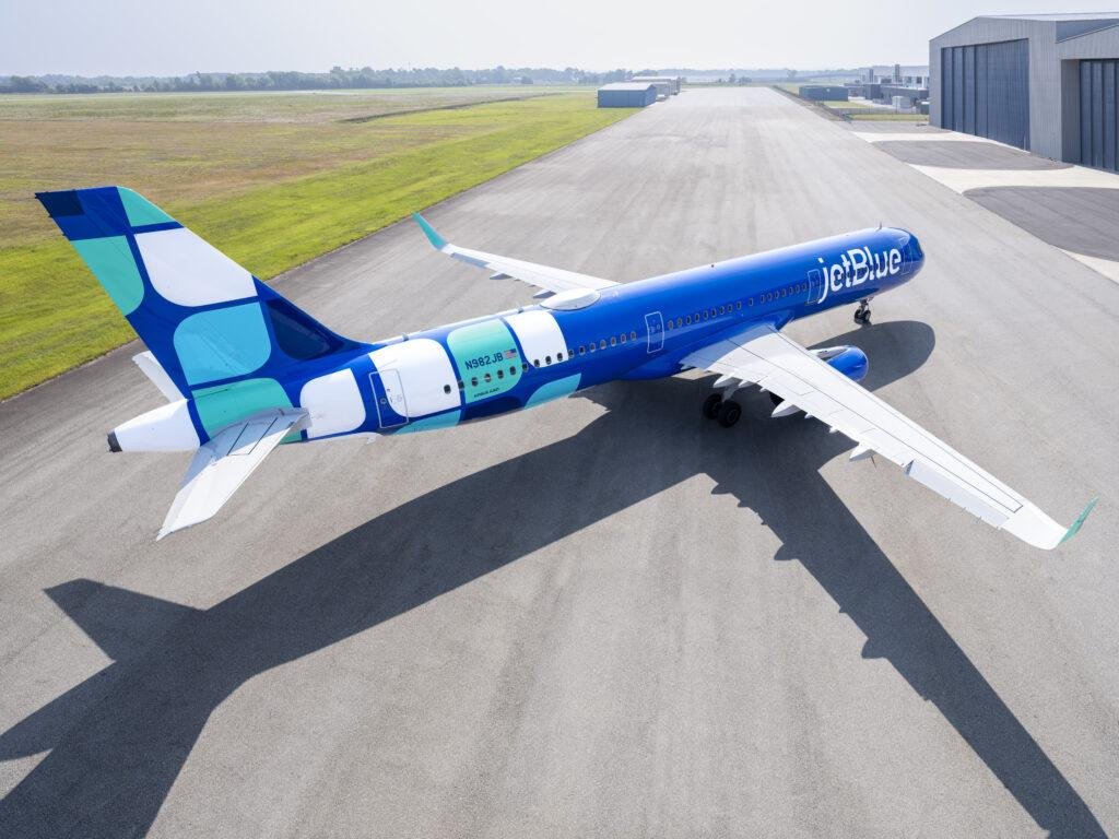 JetBlue Cali Flights illustrated by a JetBlue Airbus A321 aircraft in blue-and-turquoise Mint livery parked on an airport apron.