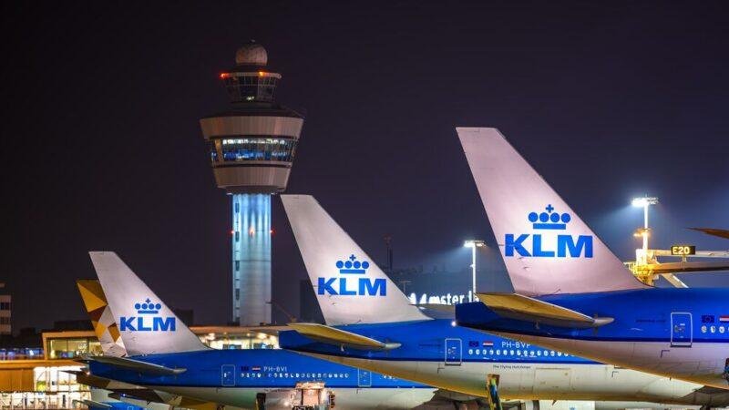 KLM Starlink Wi-Fi article illustrated by KLM aircraft parked at an airport at night, with an illuminated control tower and ground service equipment.