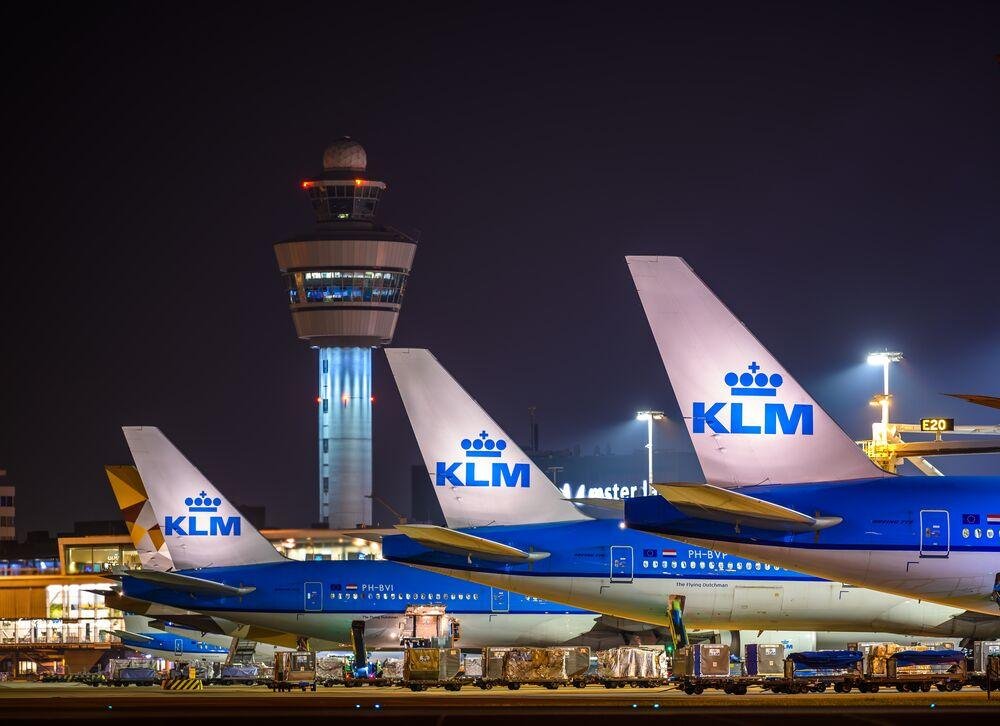 KLM Starlink Wi-Fi article illustrated by KLM aircraft parked at an airport at night, with an illuminated control tower and ground service equipment.