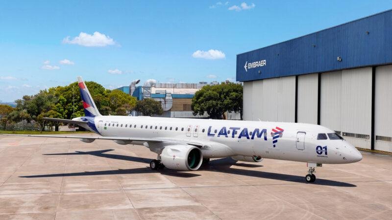LATAM Embraer delivery — E195-E2 passenger aircraft in LATAM Airlines livery parked outside an Embraer manufacturing hangar.