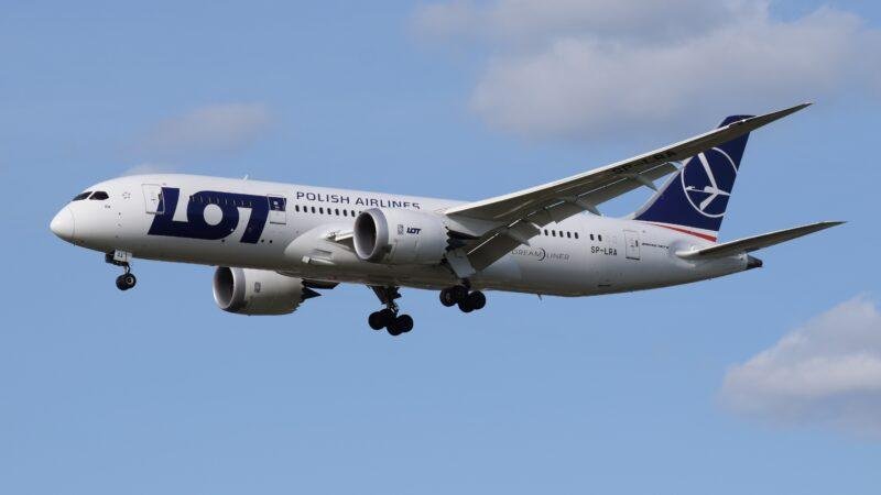 LOT Warsaw Bangkok flights illustrated by a LOT Polish Airlines Boeing 787-8 Dreamliner SP-LRA approaching landing with its landing gear extended.