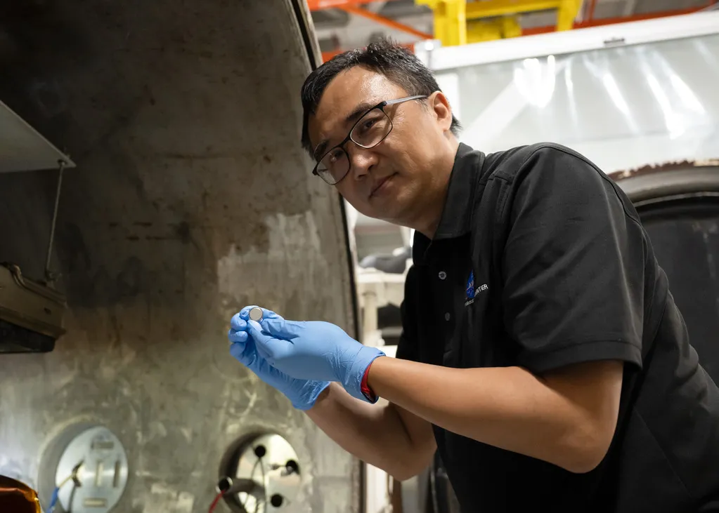 NASA SPEARS batteries researcher Yi Lin holds a prototype solid-state coin-cell battery at NASA Langley