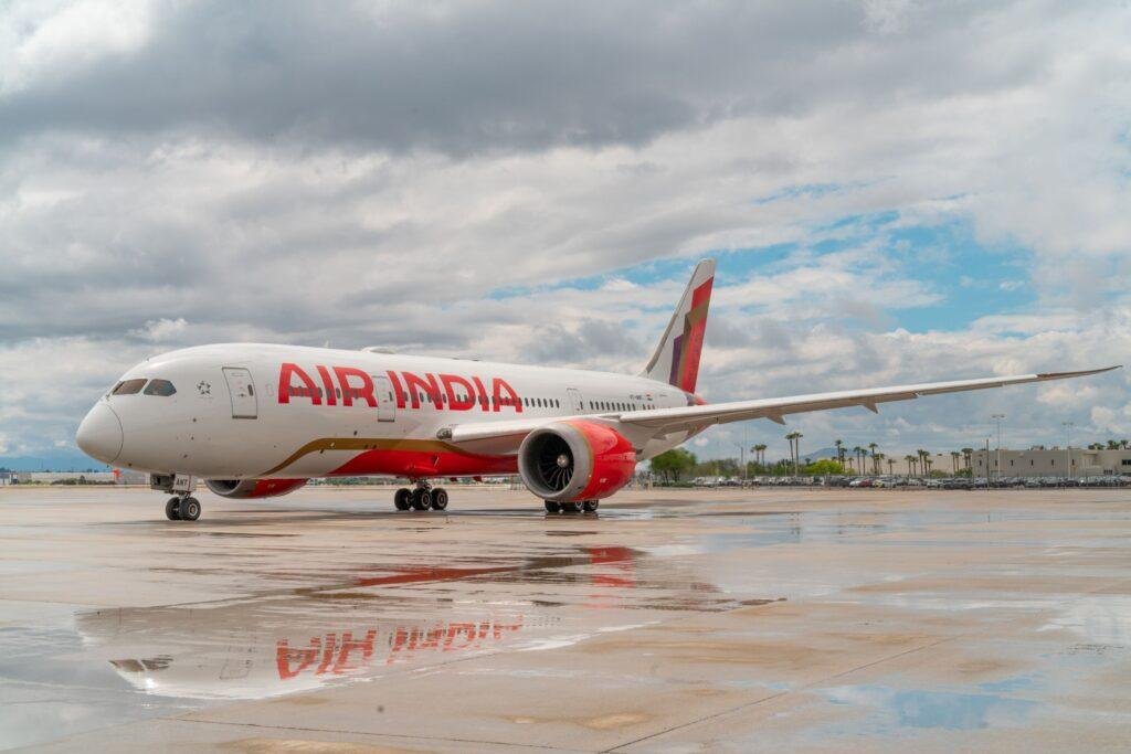 Saudi Flight Suspensions illustrated by an Air India Boeing 787 Dreamliner parked on an airport apron after rainfall.