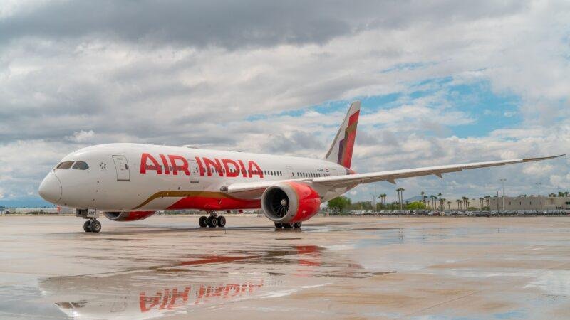 Saudi Flight Suspensions illustrated by an Air India Boeing 787 Dreamliner parked on an airport apron after rainfall.