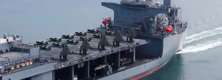 Shield AI X-BAT unmanned fighter aircraft shown in a concept rendering on a naval ship's flight deck.