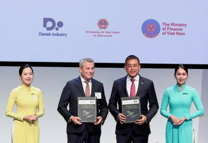 Peter Krogsgaard of Copenhagen Airport and Vietnam Airlines Chairman Đặng Ngọc Hòa hold signed memorandums of understanding at a ceremony in Denmark.